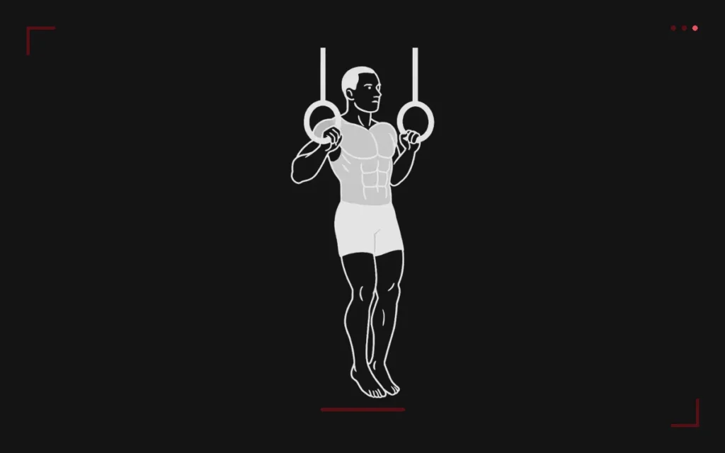 Ring muscle up: a man hanging from gymnastic rings at the top of the pull, just before the transition